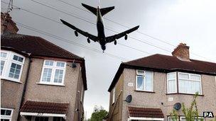 Low-flying plane passing over houses outside Heathrow Airport