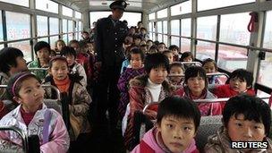 A primary school security personnel checks the number of pupils on a school bus in Zouping county, China's Shandong province, 17 November 2011