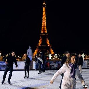 People ice skating in front of the Eiffel tower