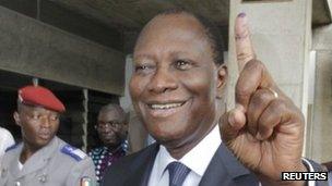 Ivory Coast's President Alassane Ouattara displays his inked stained finger after casting a ballot at a polling station in Cocody, December 11, 2011.