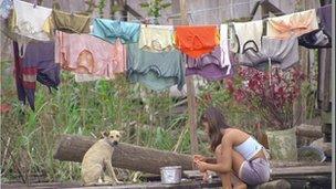 Girl washing clothes by river