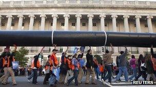 Protesters carry a mock pipeline in protest against the Keystone XL pipeline project 6 November 2011