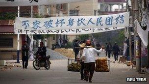 Residents walk down a street lined with protest banners in the Wukan Village in Lufeng, southern China, 20 December 2011