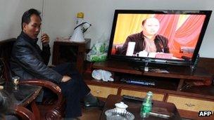 Villagers watch as Zheng Yanxiong, Communist Party Secretary of Shanwei, speaks on TV, in the village of Wukan, 20 December 2011