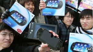 People show off their PlayStation Vita consoles in Tokyo