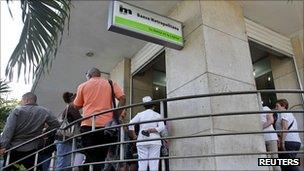 Cubans queue up outside a bank in Havana