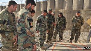 Afghan soldiers looking at a marked out concrete base for a new checkpoint