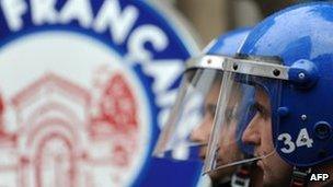 Turkish riot police officers stand guard in front of the French consulate in Istanbul, 22 December