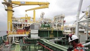 A worker inspects the FPSO OSX-1, the first floating production, storage and offloading unit in OSX"s fleet, anchored at the port of Rio de Janeiro November 2011