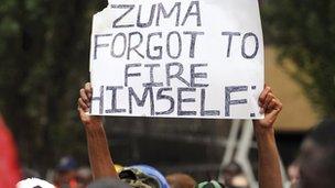 A protestor holding an anti-Zuma poster