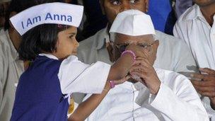 Indian social activist Anna Hazare breaks his fast with a glass of juice offered by a child at the Mumbai Metropolitan Region Development Authority (MMRDA) recreation ground in Mumbai on December 28, 2011