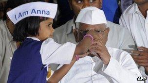 Indian social activist Anna Hazare breaks his fast with a glass of juice offered by a child at the Mumbai Metropolitan Region Development Authority (MMRDA) recreation ground in Mumbai on December 28, 2011