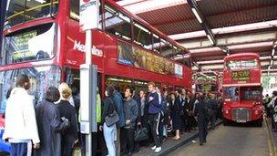 People queue for a bus