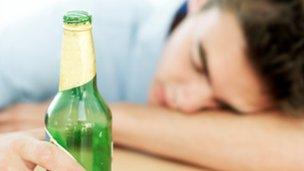 Man holds an empty beer bottle and sleeps