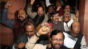 Indian Law makers from opposition parties shout slogans against ruling Congress party as they come out of parliament house after a debate on anti corruption bill in the Upper house, in New Delhi, India, Friday, Dec. 30, 2011