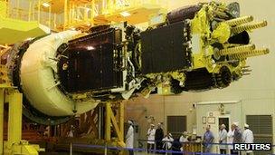 Engineers prepare a geostationary communications satellite at Baikonur Cosmodrome