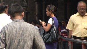 An Indian lady uses her mobile phone in the street