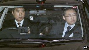 Makoto Hirata, a member of Aum Shinrikyo, rear centre, sits in a police car