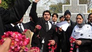 Pakistani lawyers hold rose petals as they voice support for Mumtaz Qadri