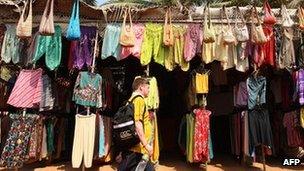 A tourist walks past shops in Goa