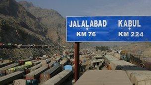 A road sign, photographed from atop gridlocked trucks, shows the distance to cities in Afghanistan after traffic was halted at the Pakistani border town Torkham November 27, 2011