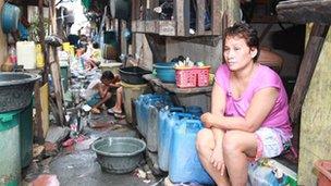 Clarita, sitting outside her one-room home in Manila