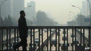 A man walks over the Second Ring Road in Beijing, 22 November 2011