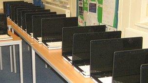 Laptop computers lined up on school desks