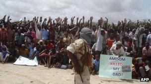 Somali men carry weapons during a demonstration organised by the Islamist al-Shabab group 5 July 2010