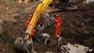 Rescue personnel recover the body of a mudslide victim in Jamapara, Rio de Janeiro state, Brazil, Tuesday 10 January 2012