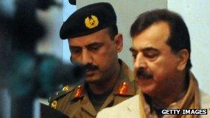 Pakistan's Prime Minister Yousuf Raza Gilani pays his respects over the grave of slain former Pakistani premier Benazir Bhutto on her fourth death anniversary at the Bhutto family mausoleum in Garhi Khuda Bakhsh on December 27, 2011.