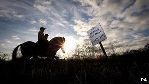 Riders from Crowberry Stables in Middleton, pass a sign marking a bridge on the proposed HS2 line near Middleton, Warwickshire