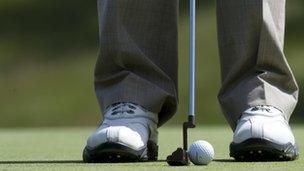 Golfer lines up a ball