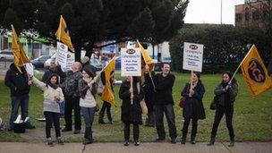 PCS (Public and Commercial Services) union members wave flags at cars near Heathrow Airport, west of London, on November 30, 2011, as they take part in a national strikes against pension cuts.