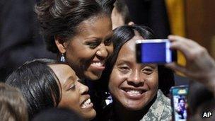 Michelle Obama poses for a photo with US Army Staff Sergeants 11 January 2012