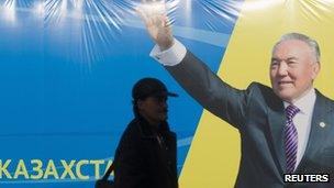 A man in Almaty walks by an election poster of the Nur Otan party led by President Nursultan Nazarbayev. Photo: January 2012