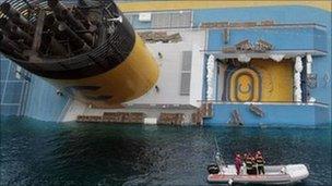 Italian divers approach the cruise ship Costa Concordia leaning on its side, 15 January