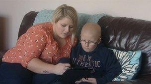 Mason Fountain and his mother, Shelley, look at a computer