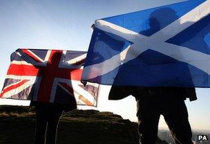 Two men wave a Union and Saltire flags in Edinburgh, Scotland