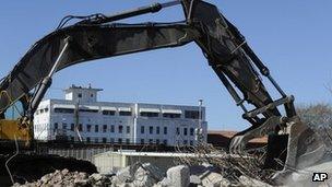 A crane digs into a pile of debris previously the Texas Prison Rodeo in Huntsville, Texas on 11 January 2012