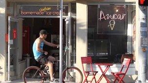 A man cycles past the storefront