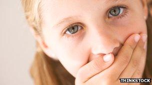 Child covering mouth with hand