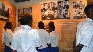 Rwandan school children looking at a display about genocides around the world