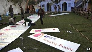 Workers put up the posters at the Jaipur Literature Festival, in Jaipur, in the Western Indian state of Rajasthan, Thursday, Jan. 19, 2012