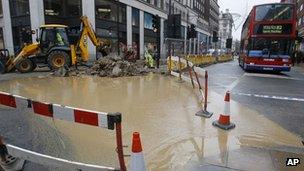 A bus drives around flood water in Oxford Street