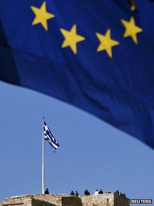 An EU flag flies as tourists visit the ancient hill of Acropolis in Athens