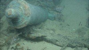 Bronze cannon protruding from a sandbank on the shipwreck site of HMS Victory