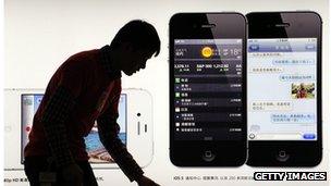 A consumer looks at an iPhone poster in China