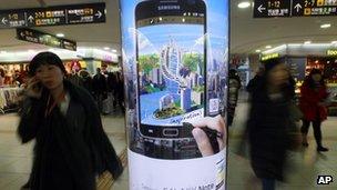 People walk by a billboard of Samsung Electronics Galaxy Note at a subway station in Seoul, South Korea, on 6 January, 2012