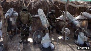 Soldiers stand next to distillers at an outdoor clandestine drug processing laboratory discovered in Tlajomulco de Zuniga, on the outskirts of Guadalajara 23 January 2012.